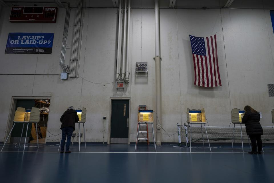 FILE- In this Nov. 3, 2020, file photo people vote at the Milwaukee County Sports Complex in Franklin, Wis. The Wisconsin Supreme Court sided with Democrats on Friday, April 9, 2020, and ruled that the state elections commission should not remove from the rolls voters flagged as possibly having moved, something conservatives have wanted done for nearly two years. (AP Photo/Morry Gash)