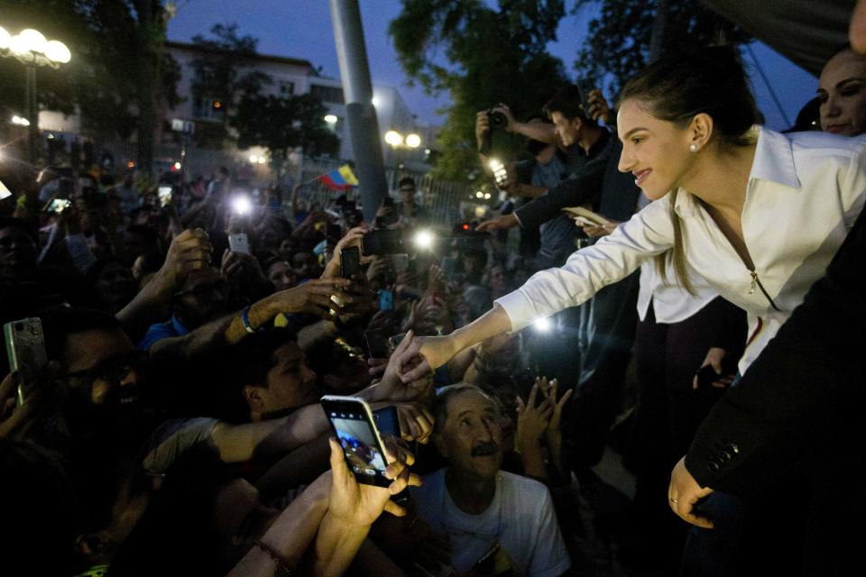 In this Wednesday, March 20, 2019 photo, Fabiana Rosales de Guaido, wife of Venezuela's self-proclaimed interim president Juan Guaido, shakes hands with a supporter during a meeting with Venezuelan residents in Chile, in Santiago, Chile. Rosales is in Chile for the Democracy Forum Santiago 2019. (AP Photo/Esteban Felix)