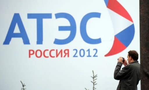 A man takes a photo of a Russian billboard of the Asia-Pacific Economic Cooperation (APEC) summit in Vladivostok on September 4, 2012. APEC leaders' summit in Russia's far eastern port city of Vladivostok will take place on September 8 and 9