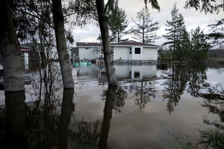 Flood waters of the Snoqualmie River surround a residence off State Route 203 during a storm in Carnation, Washington December 9, 2015. REUTERS/Jason Redmond