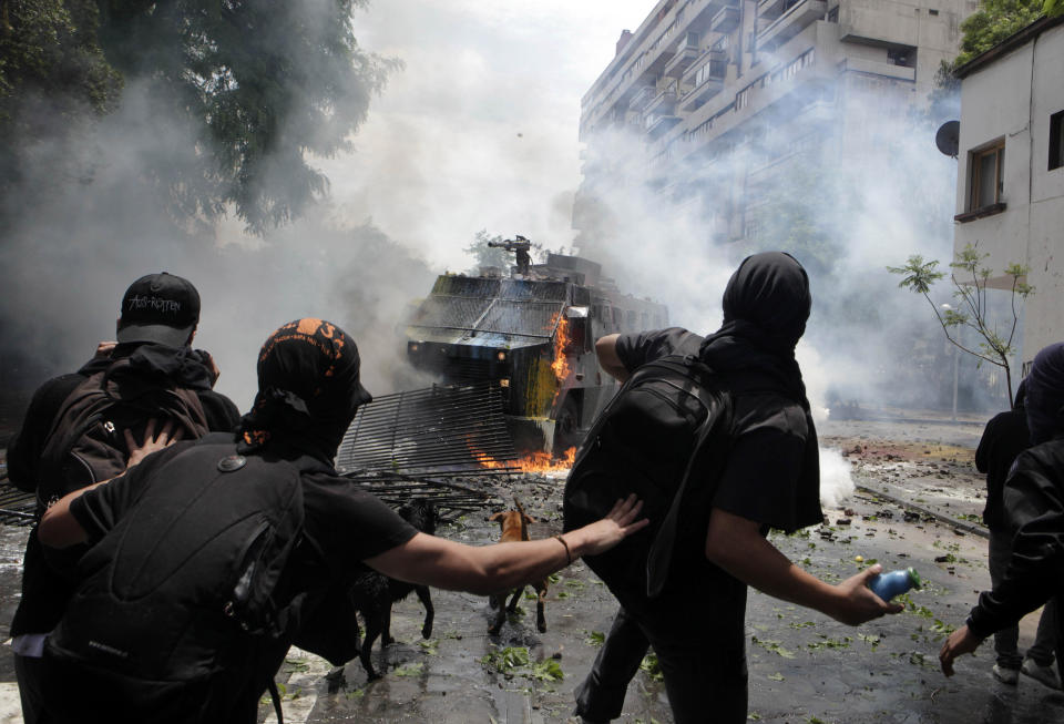 FILE - In this Nov 18, 2011 file photo, demonstrators confront a police water cannon as they protest to demand education reform in Santiago, Chile. The 2011 demonstrations by university students won free tuition for nearly half the students in the country, and lower interest rates on student loans. (AP Photo/Luis Hidalgo, File)