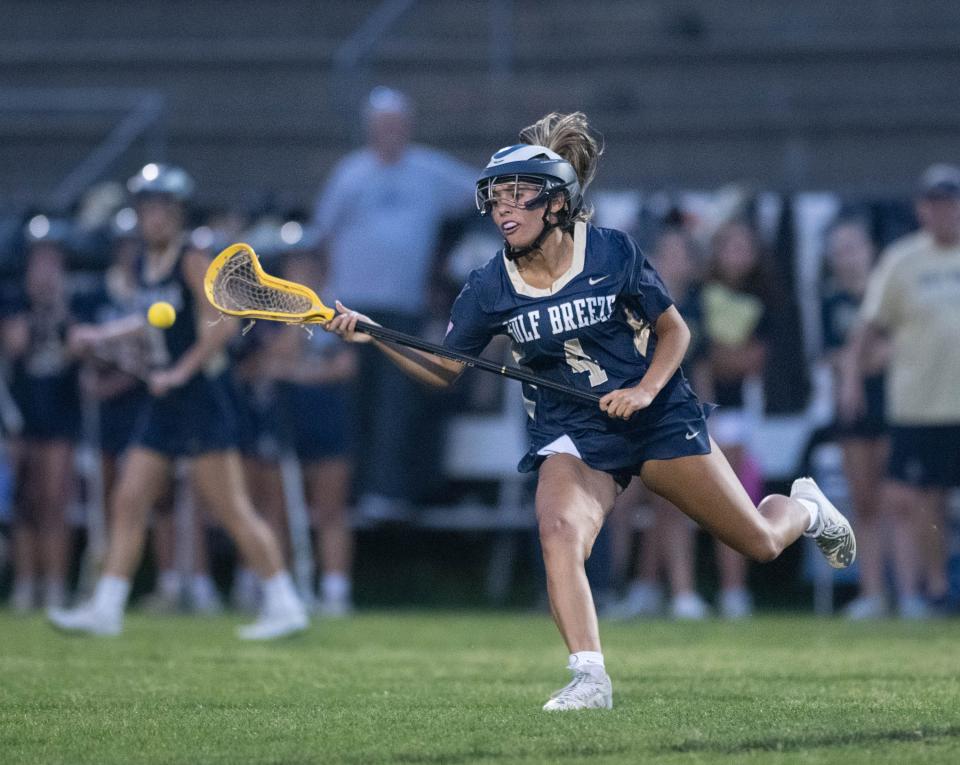 Isabelle Owens (4) goes after a loose ball during the Gulf Breeze vs Catholic girls lacrosse game at Pensacola Catholic High School on Friday, March 31, 2023.
