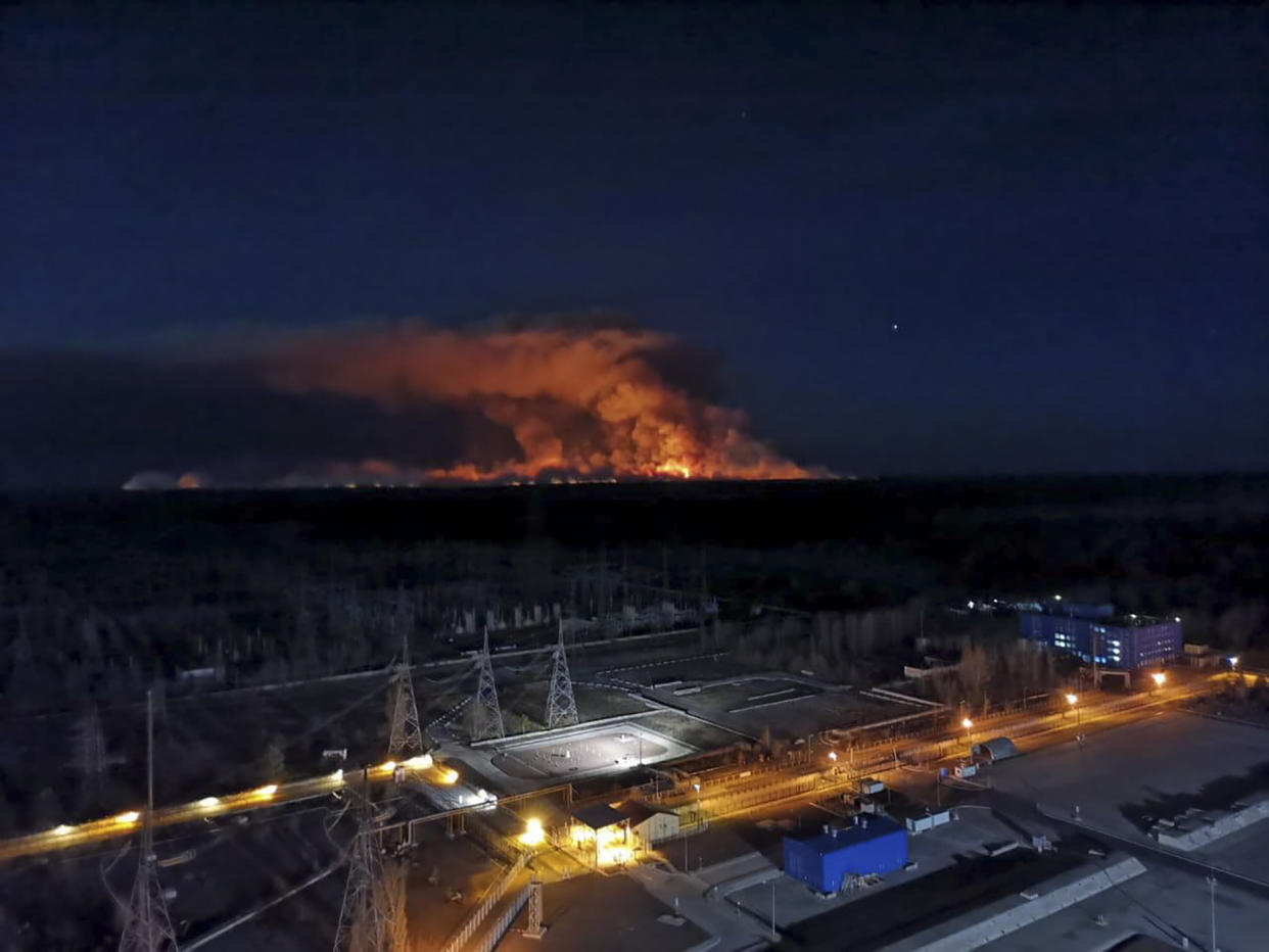 In this photo taken from the roof of Ukraine's Chernobyl nuclear power plant late Friday April 10, 2020, a forest fire is seen burning near the plant inside the exclusion zone.  Ukrainian firefighters are labouring to put out two forest blazes in the area around the Chernobyl nuclear power station that was evacuated because of radioactive contamination after the 1986 explosion at the plant. (Ukrainian Police Press Office via AP)