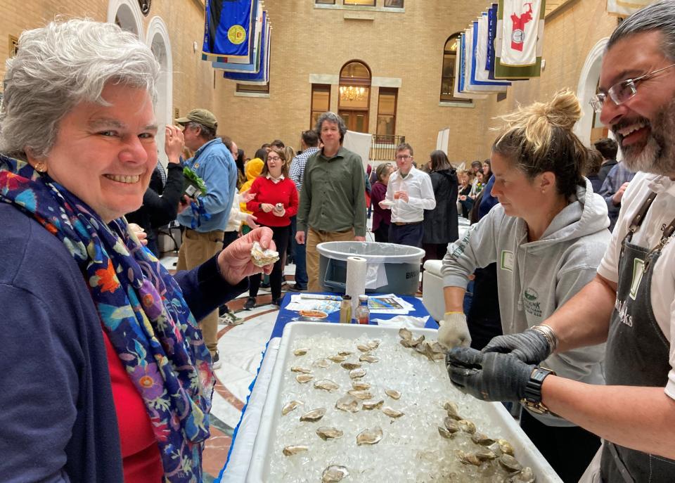 Rep. Kate Donaghue, D-Westborough, takes a taste outside of her district, sampling Buzzards Bay oysters provided by Padanaram farmer Scott Soares at Ag-Day Wednesday at the Massachusetts State House.