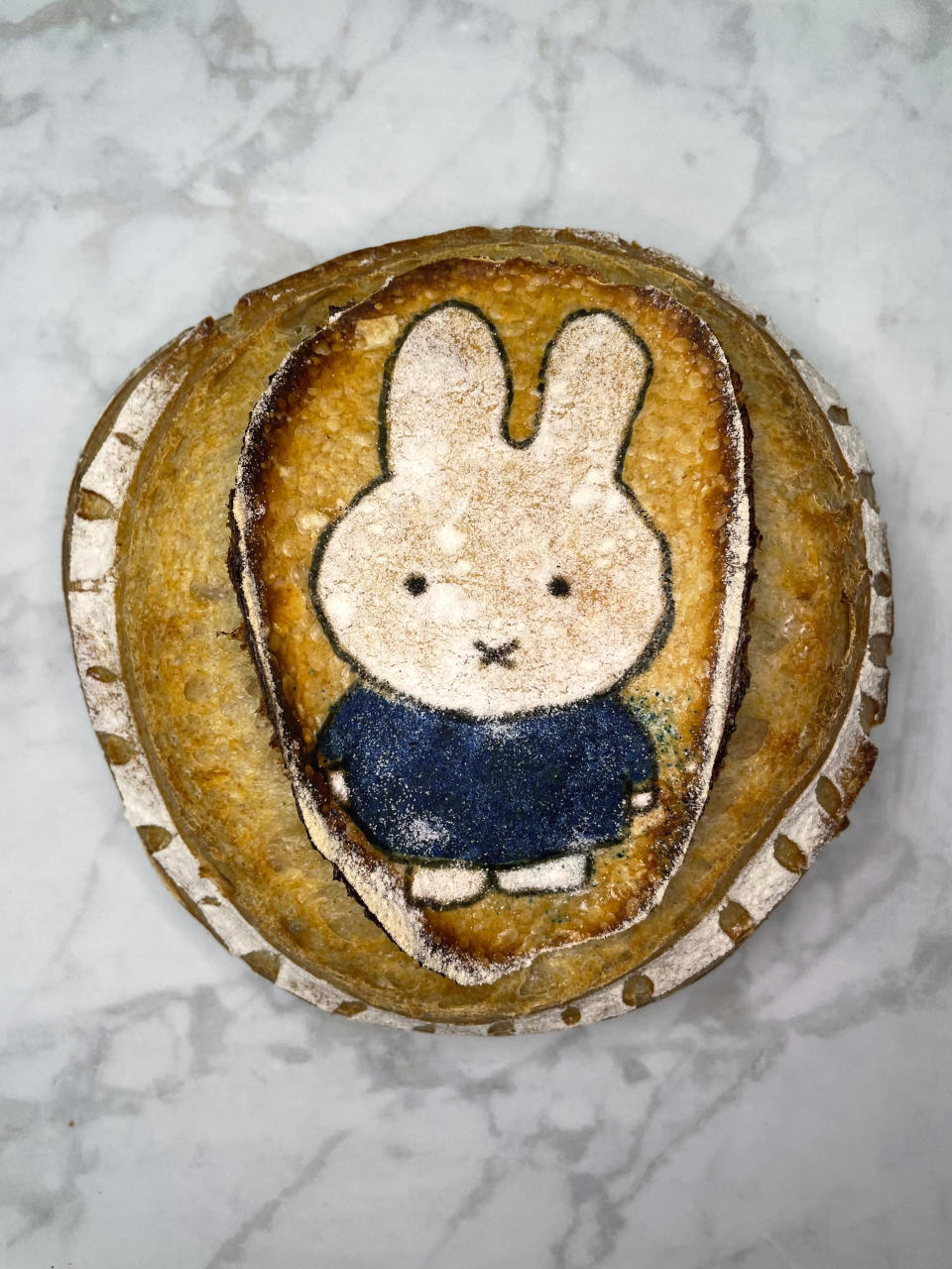 This undated photo provided by Kelson Herman shows a sourdough boule with an illustration of Miffy, a rabbit from a popular Dutch picture book series, made by Herman in his San Francisco home for Lunar New Year. (Kelson Herman via AP)