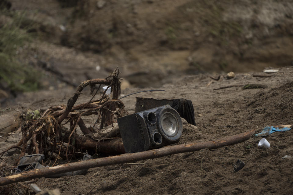 A speaker and debris lay on the ground close to the area where firefighters search for survivors after homes of the "Dios es fiel," or God is Loyal shanty town were swept away overnight by a swollen Naranjo River, on the outskirts of Guatemala City, Monday, Sept. 25, 2023. (AP Photo/Moises Castillo)