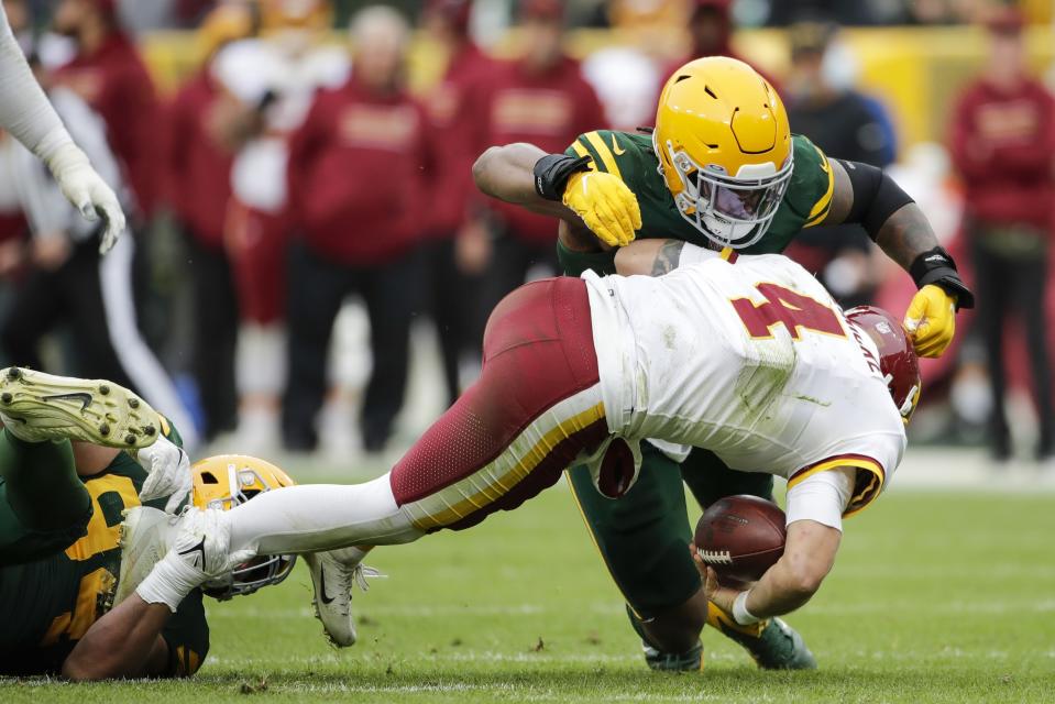 Green Bay Packers' Dean Lowry and Rashan Gary sack Washington Football Team's Taylor Heinicke during the second half of an NFL football game Sunday, Oct. 24, 2021, in Green Bay, Wis. The Packers won 24-10. (AP Photo/Aaron Gash)