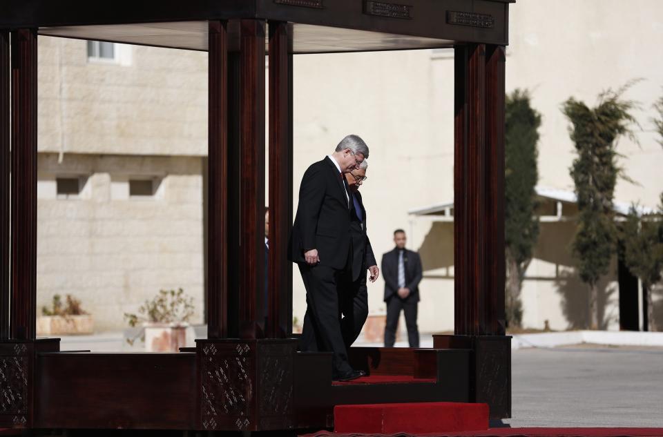 Canada's Prime Minister Stephen Harper and Palestinian President Abbas walk together during an honour guard ceremony in Ramallah