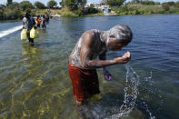 A Haitian migrant uses the Rio Grande to take a bath after crossing a dam from Mexico to the United States, Friday, Sept. 17, 2021, in Del Rio, Texas. Thousands of Haitian migrants have assembled under and around a bridge in Del Rio presenting the Biden administration with a fresh and immediate challenge as it tries to manage large numbers of asylum-seekers who have been reaching U.S. soil. (AP Photo/Eric Gay)