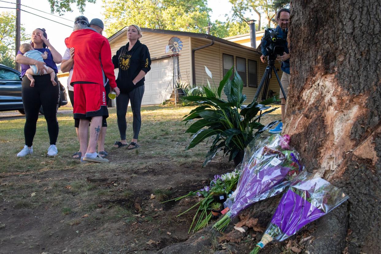 Mourners gather and lay flowers and gifts at the site of a deadly car crash during an impromptu memorial service on Sunday, Oct. 2, 2022, in Lincoln, Neb. Police in Nebraska said a passenger’s cellphone automatically alerted responders after a car hit a tree in a crash that killed all of its young occupants.