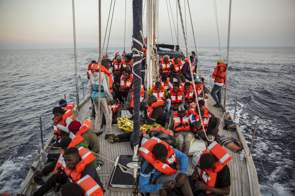 Migrants rest on a Mediterranea Saving Humans NGO boat, as they sail off Italy's southernmost island of Lampedusa, just outside Italian territorial waters, on Thursday, July 4, 2019. An Italian humanitarian group whose boat has been barred from docking in Lampedusa said the health of the 54 migrants it rescued at sea is rapidly deteriorating, prompting fears of another standoff with Italy's populist government. Mediterranea Saving Humans said Friday in a tweet that its sailing boat ALEX was off Italy's southernmost island of Lampedusa, just outside Italian territorial waters, and that it has been banned from entering Italian jurisdiction by ministerial decree. (AP Photo/Olmo Calvo)