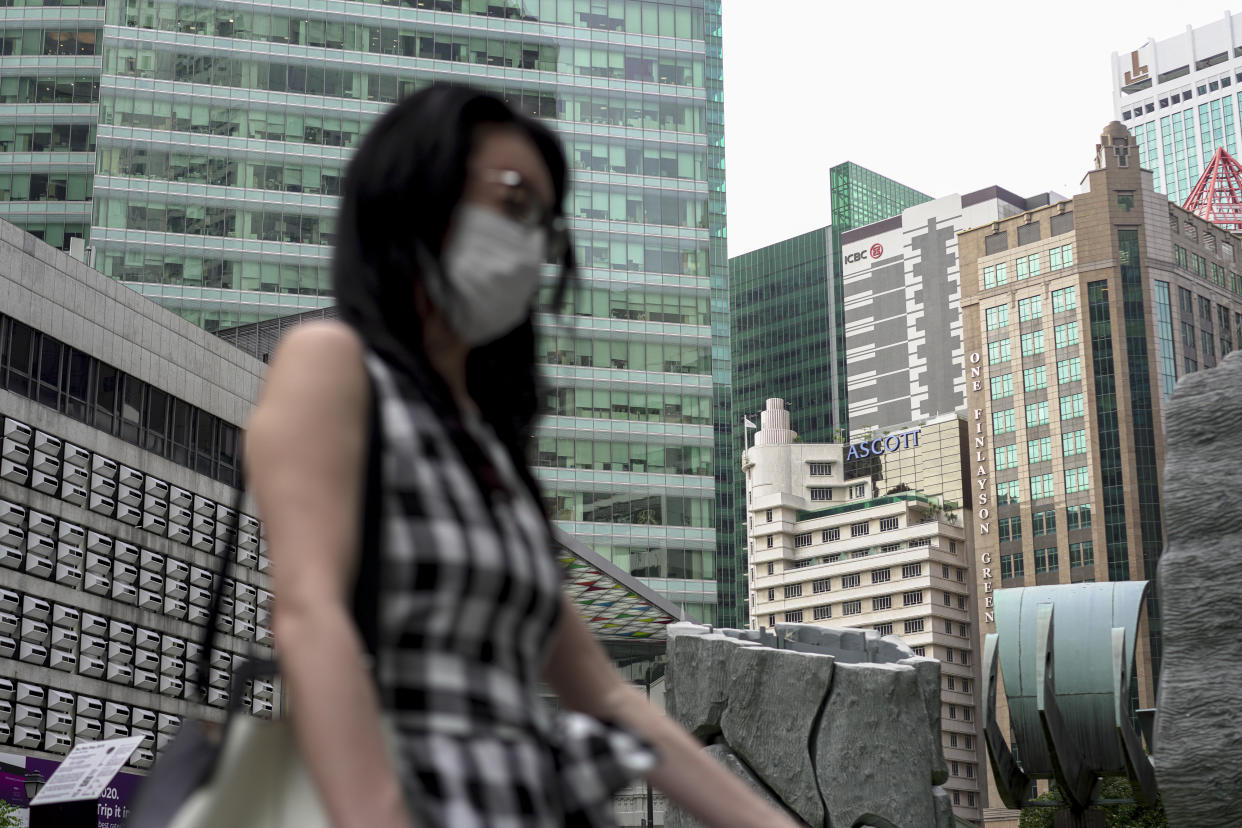 SINGAPORE, SINGAPORE - FEBRUARY 28: A lady wearing a mask walks past buildings at the Central Business District on February 28, 2020 in Singapore. The coronavirus, originating in Wuhan, China has spread to over 80,000 people globally, more than 50 countries have now been infected.  (Photo by Ore Huiying/Getty Images)