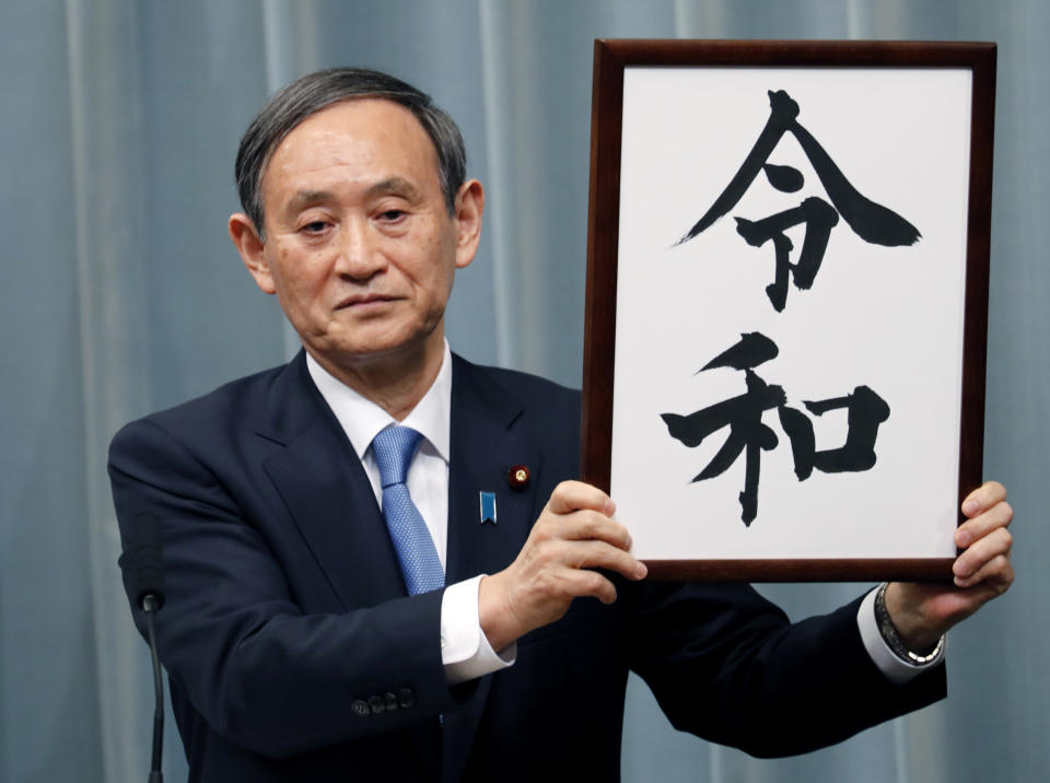 In this Monday, April 1, 2019, file photo, Japan’s Chief Cabinet Secretary Yoshihide Suga unveils the name of new era “Reiwa” at the prime minister’s official residence in Tokyo. Japan says next emperor Naruhito’s era name is Reiwa, effective May 1 when he takes the throne from his father. (AP Photo/Eugene Hoshiko, File)