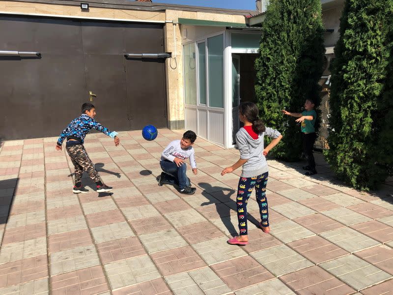 Children play with a ball at a diamond-cutting factory where they found shelter after fleeing the fighting over the breakaway region of Nagorno-Karabakh, in Abovyan