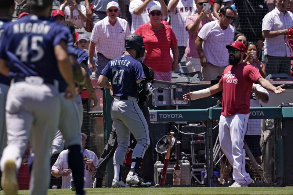 Seattle Mariners' Jesse Winker (27) gets set to fight with Los Angeles Angels Anthony Rendon after he was hit by a pitch and went after players in the Angels dugout during the second inning of a baseball game Sunday, June 26, 2022, in Anaheim, Calif. (AP Photo/Mark J. Terrill)