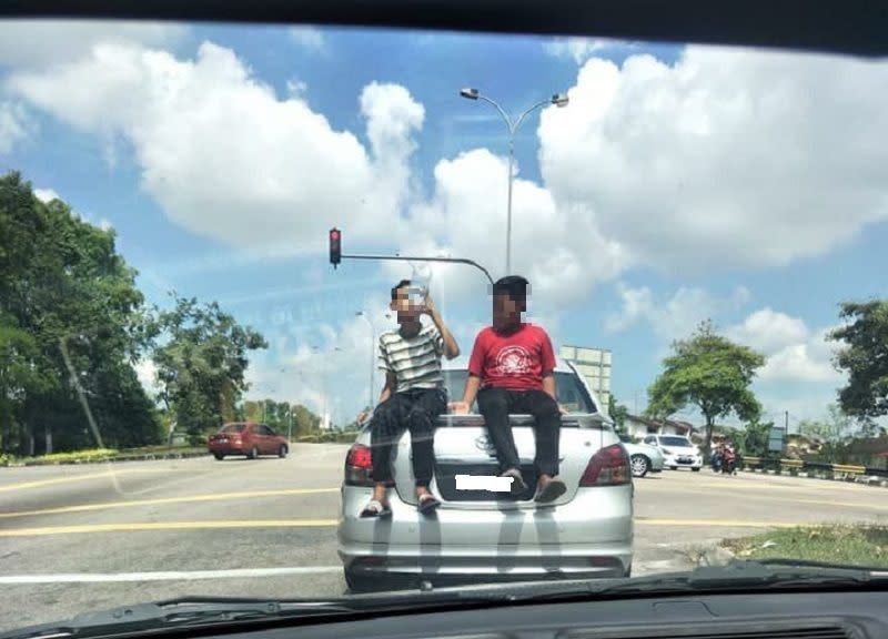 A screen capture of the video showing the two boys seated at the back of a moving silver Toyota Vios. — Picture courtesy of Armada JB WhatsApp group