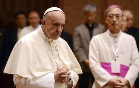 Pope Francis prays as he arrives the headquarters of the Korean Bishops's Conference to attend a meeting with the bishops in Seoul August 14, 2014. REUTERS/Korea Pool/News1