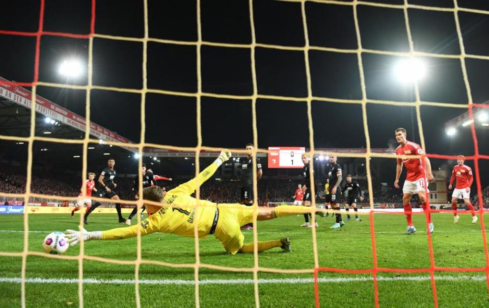 Union Berlin's Kevin Volland scores past Augsburg goalkeeper Finn Dahmen