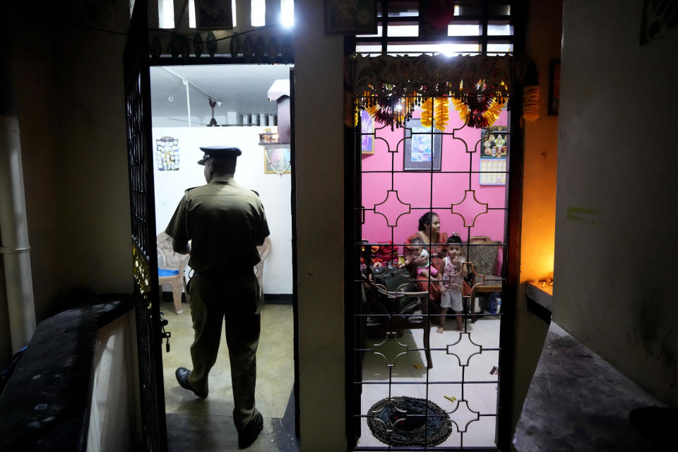 A Sri Lankan police officer enters a house to search for proscribed items during a search operation against narcotics in Colombo, Sri Lanka, Thursday, Jan. 18, 2024. (AP Photo/Eranga Jayawardena)