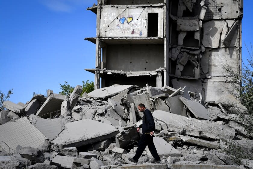 A local resident walks next to a house destroyed in a Russian shelling in Kramatorsk, Ukraine, Wednesday, May 25, 2022.