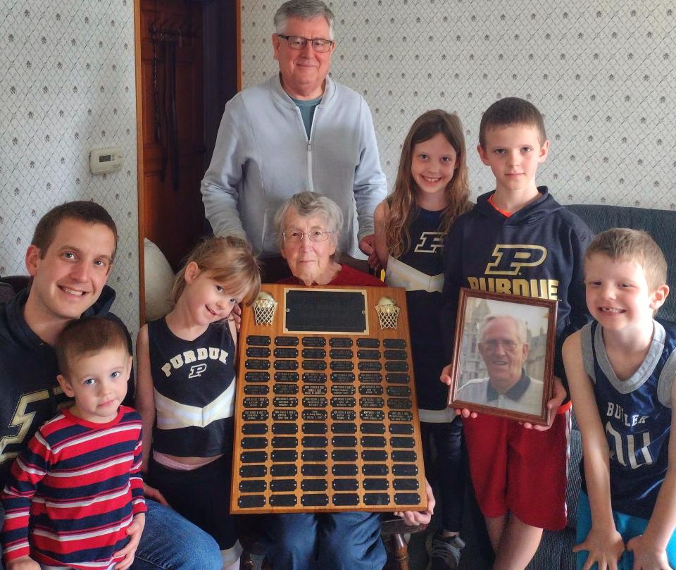 The Hart family has been doing March Madness brackets since 1981. Each year, the winner gets their name on a plaque (held by Jo Ann Hart whose husband Nelson Hart started the tradition). Four generations of Harts are shown in this photo. Jo Ann with her son, Michael, standing behind her and grandson Joel, far left, with great grandchildren, from left, Seth, Esther, Jenny, David (holding a photo of Nelson) and Elisha.