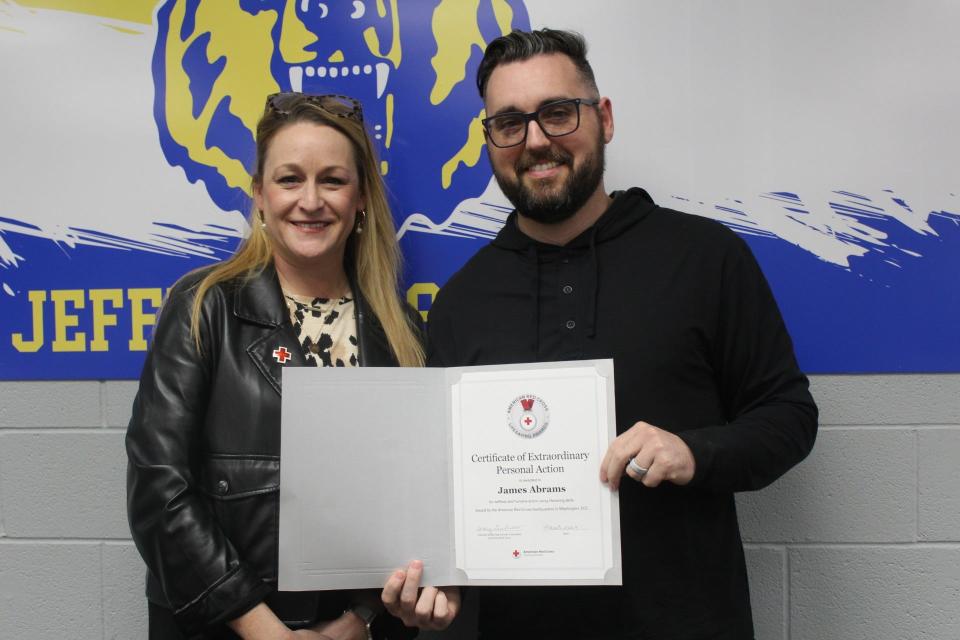 Jefferson High School dean James Abrams holds the award he received from Rachel Hepner, executive director of the American Red Cross of Western Lake Erie.