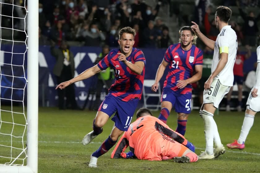 Cole Bassett, left, celebrates after scoring past Bosnia and Herzegovina goalie Belmin Dizdarevic, bottom center.