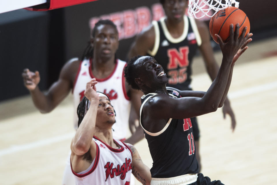 Nebraska's Lat Mayen, right, goes under the basket to score against Rutgers' Caleb McConnell in the first half of an NCAA college basketball game Monday, March 1, 2021, in Lincoln, Neb. (Kenneth Ferriera/Lincoln Journal Star via AP)