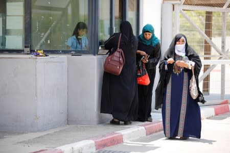 Palestinian women stand next to the counter of an Israeli official at the Israeli side of Erez crossing, on the border with Gaza