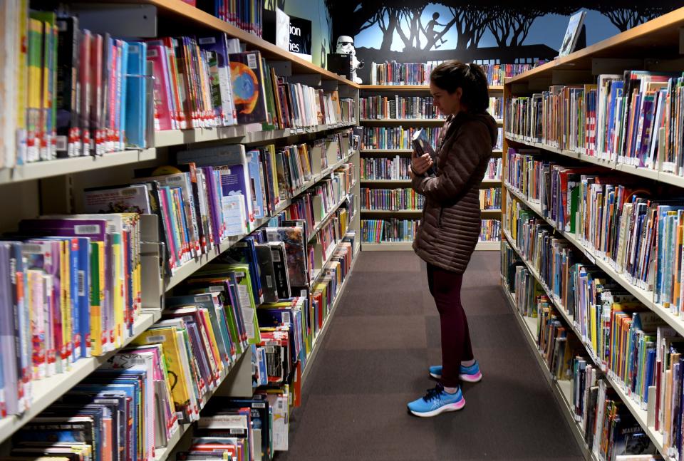 Lindsay Kahlenberg of Green picks out a selection of books for her children on a recent trip to North Canton Public Library.