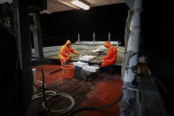 Francesco Di Bartolomeo, left, and Francesco select fish aboard the trawler Marianna, during a fishing trip in the Tyrrhenian Sea, early Thursday morning, April 2, 2020. Italy’s fishermen still go out to sea at night, but not as frequently in recent weeks since demand is down amid the country's devastating coronavirus outbreak. For one night, the Associated Press followed Pasquale Di Bartolomeo and his crew consisting of his brother Francesco and another fishermen, also called Francesco, on their trawler Marianna. (AP Photo/Andrew Medichini)