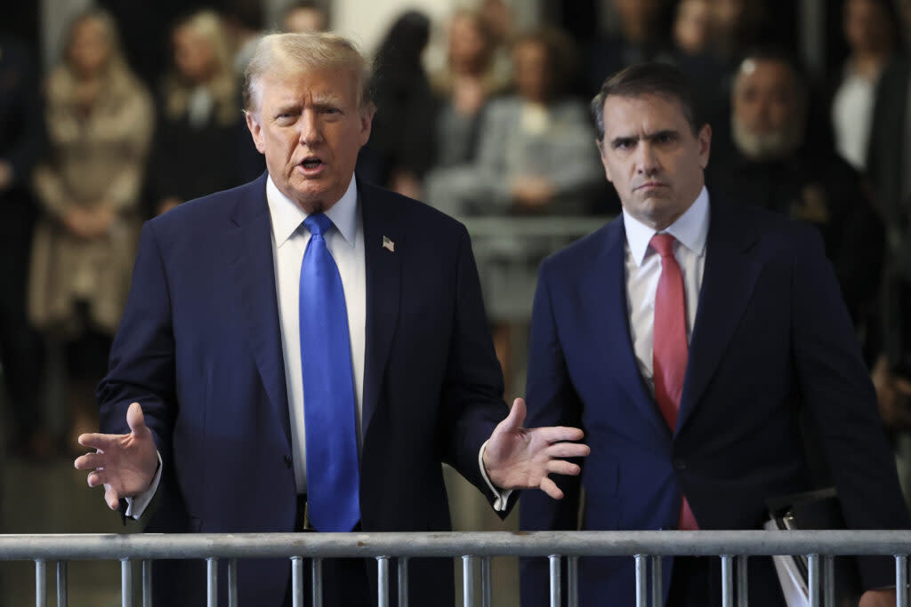 Former U.S. President Donald Trump speaks to the media as he arrives with his attorney Todd Blanche, right, in court for opening statements in his trial for allegedly covering up hush money payments at Manhattan Criminal Court on April 22, 2024, in New York City. Trump faces 34 felony counts of falsifying business records in the first of his criminal cases to go to trial.