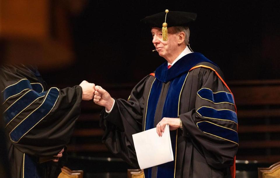 David Dockery, president of Southwestern Baptist Theological Seminary, fist bumps a staff member before the start of graduation at the seminary on Friday, May 5, 2023, in Fort Worth.