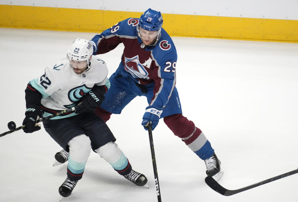 Seattle Kraken right wing Oliver Bjorkstrand, left, battles for control of the puck with Colorado Avalanche center Nathan MacKinnon in the third period of Game 7 of an NHL first-round playoff series Sunday, April 30, 2023, in Denver. The Kraken won 2-1 to advance to the next round. (AP Photo/David Zalubowski)