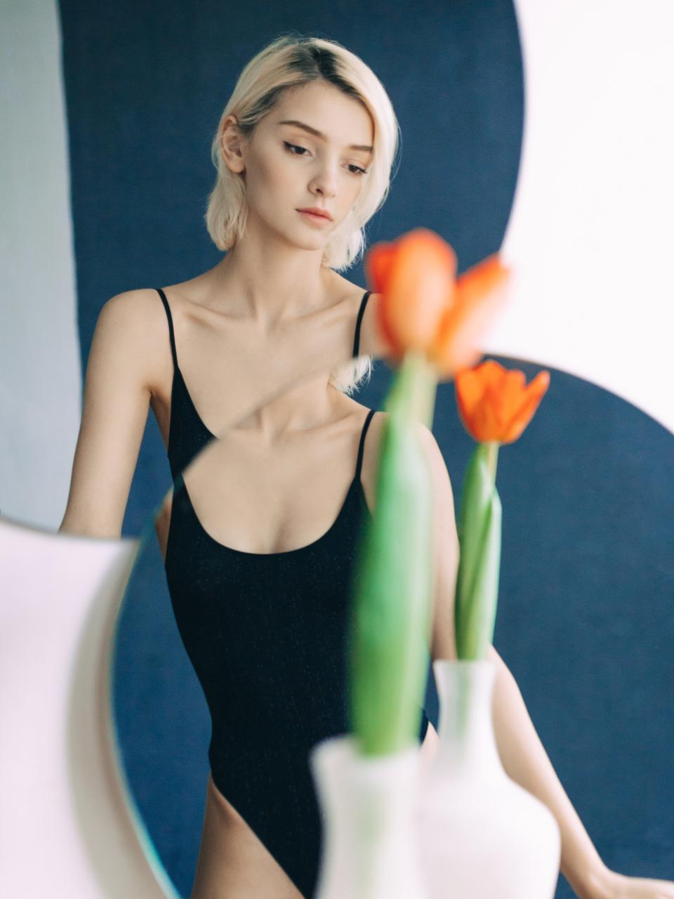 <h1 class="title">Young woman reflected in mirror with red tulip</h1><cite class="credit">Getty Images</cite>