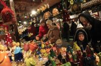 People look at Christmas decorations at a stall at the Budapest Christmas Fair at Vorosmarty square in downtown Budapest, December 11, 2013. REUTERS/Bernadett Szabo (HUNGARY - Tags: SOCIETY TRAVEL)