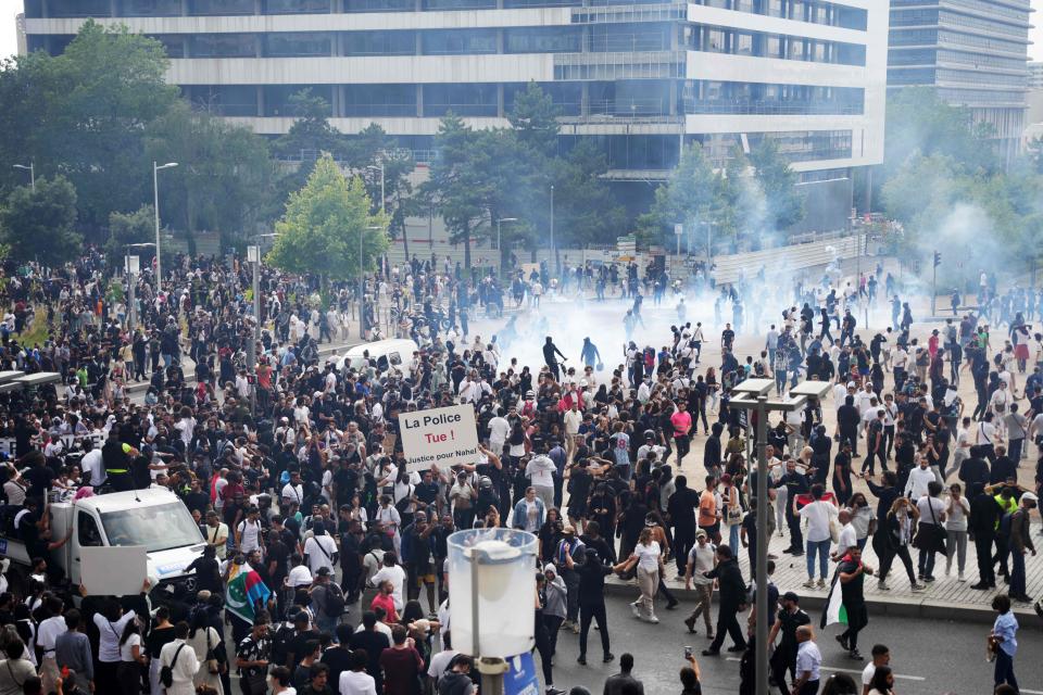 Protestors hold a placard reading "The police kill! Justice for Nahel" during a commemoration march for a teenage driver shot dead by a policeman, in the Parisian suburb of Nanterre, on June 29, 2023.