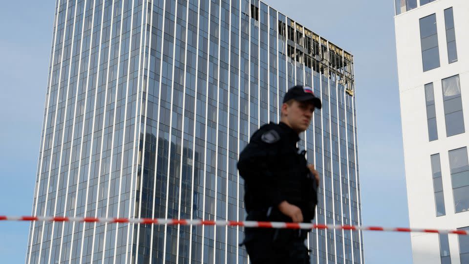 A member of the security services stands guard next to a damaged building in the Russian capital on Monday. - Maxim Shemetov/Reuters