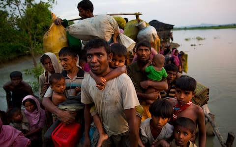 Rohingya Muslims carry their young children and belongings after crossing the border from Myanmar into Bangladesh, near Palong Khali - Credit: Bernat Armangue/AP