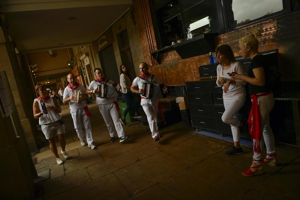 <p>Musicians dressed in white and red clothes play music along the old city at the end of the fourth running of the bulls, during the San Fermin Festival, in Pamplona, northern Spain, July 10, 2017. (AP Photo/Alvaro Barrientos) </p>