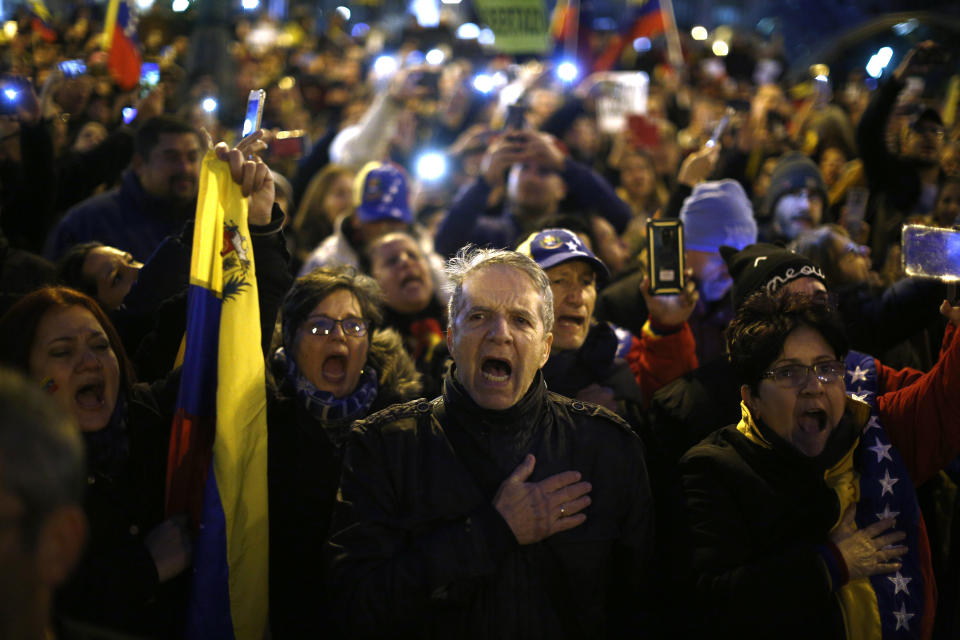 People gather during a protest Venezuela's Nicolas Maduro and in support of an opposition leader self-proclaimed as the interim president of the country in Madrid, Spain, Wednesday, Jan. 23, 2019. Around 7,000 protesters according to organizers, gathered in a central square of the Spanish capital, where a significant Venezuelan community has grown in recent years with people fleeing persecution or poverty at home. (AP Photo/Manu Fernandez)