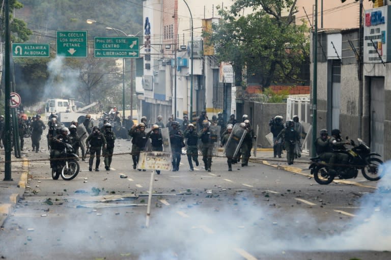 Riot police and opposition activists clash in Caracas on April 10, 2017 after Venezuela's political crisis intensified following the Supreme Court's ruling that curbed the powers of the opposition-controlled legislature