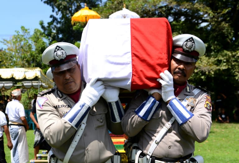 Indonesian policemen carry the coffin containing the body of police officer Wayan Sudarsa, killed on resort island of Bali, during his funeral on August 21, 2016