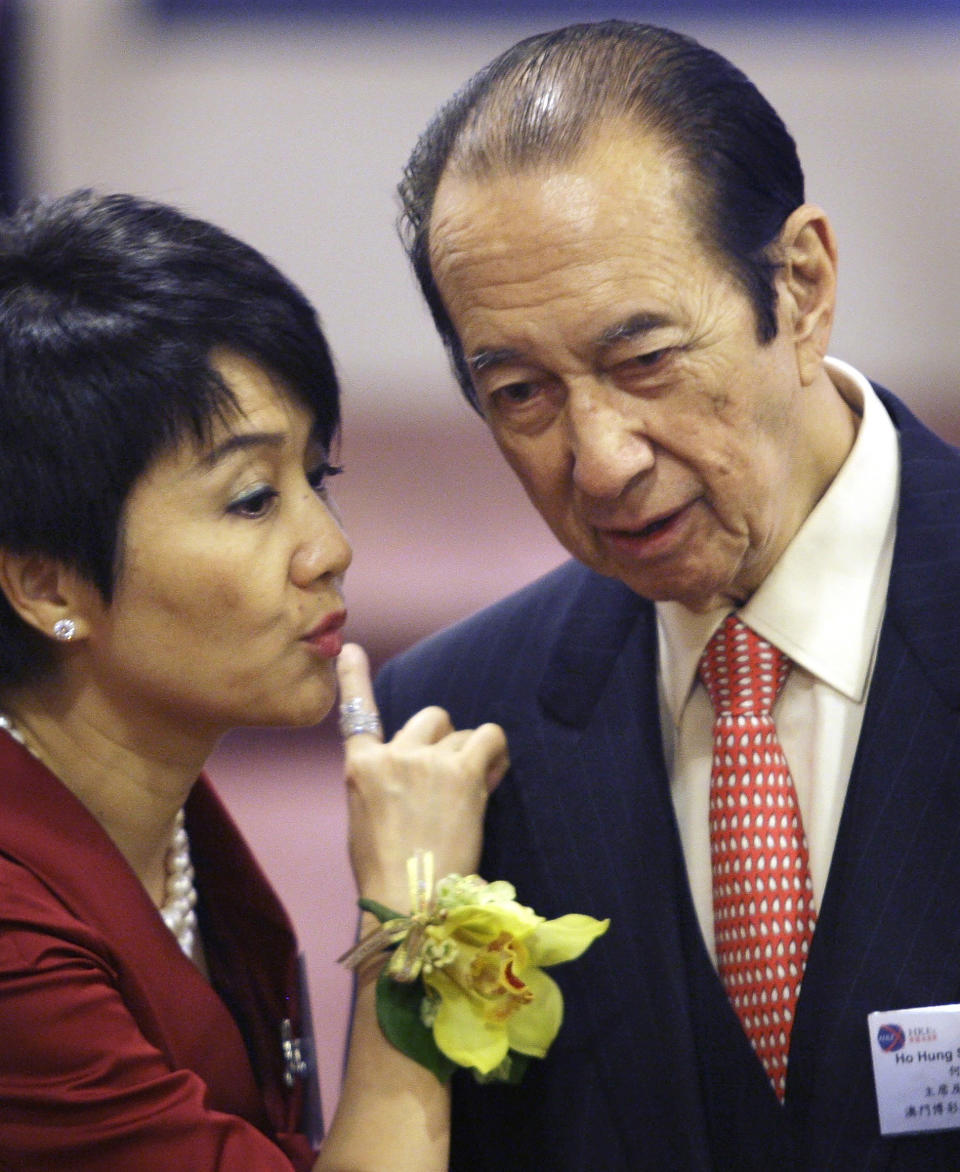 FILE - In this July 16, 2008, file photo, Macau tycoon Stanley Ho, right, talks with his wife Angela Leong On Kei during the listing ceremony of Sociedade de Jogos de Macau, or SJM, Holdings Ltd. at the Hong Kong Stock Exchange in Hong Kong. On Tuesday, May 26, 2020, the family of Stanley Ho, the Macao casino tycoon considered the father of modern gambling in China, has died at 98.(AP Photo/Vincent Yu, File)