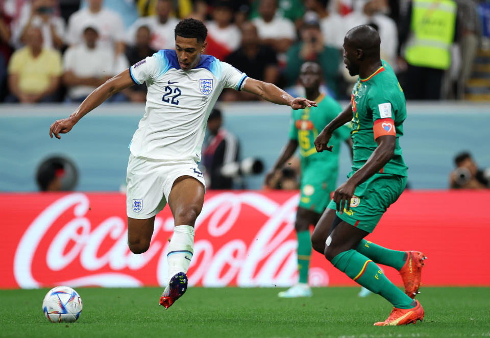 England's Jude Bellingham (left) runs with the ball under pressure from Senegal's Kalidou Koulibaly during their last-16 clash at the 2022 World Cup.
