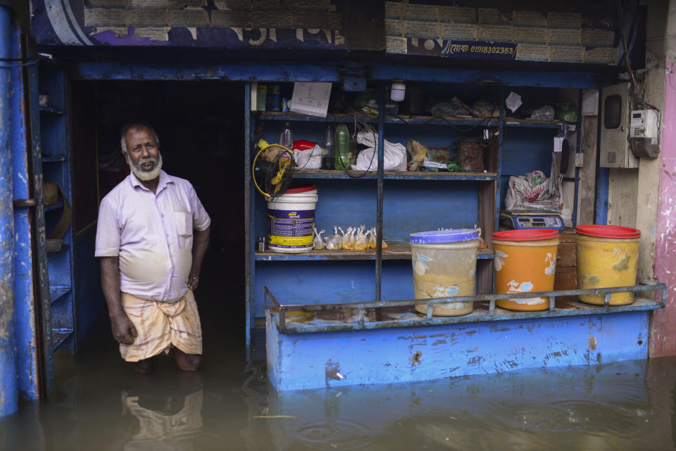 A man stands at the doorway of his flooded shop in Sylhet, Bangladesh, Monday, June 20, 2022. Floods in Bangladesh continued to wreak havoc Monday with authorities struggling to ferry drinking water and dry food to flood shelters across the country’s vast northern and northeastern regions. (AP Photo/Mahmud Hossain Opu)