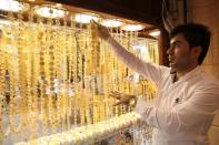 A goldsmith shop owner displays gold pieces at a gold market in Arbil, in Iraq's Kurdistan region