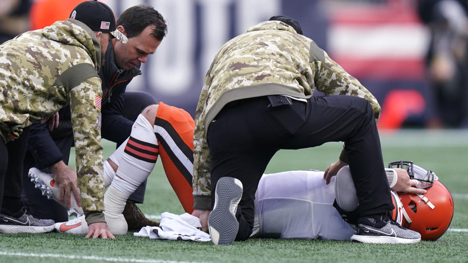 Cleveland Browns quarterback Baker Mayfield (6) is examined on the field after an apparent injury during the second half of an NFL football game against the New England Patriots, Sunday, Nov. 14, 2021, in Foxborough, Mass. (AP Photo/Steven Senne)