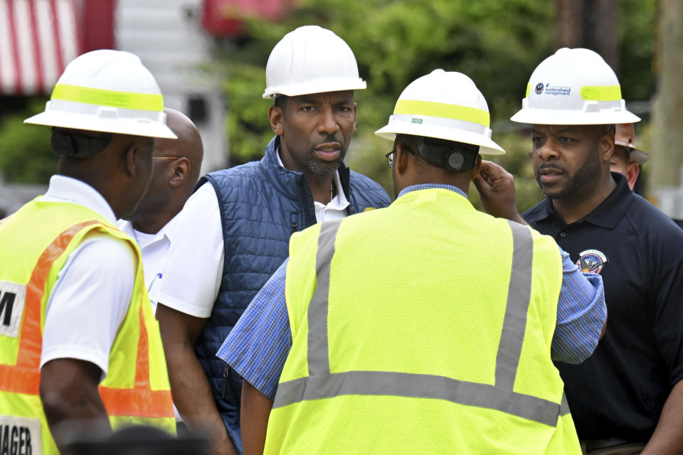 Mayor Andre Dickens and Commissioner of Department of Watershed Management Al Wiggins, Jr., right, confer with staff at Joseph E. Boone Boulevard and James P. Brawley Drive, Saturday, June 1, 2024, in Atlanta. City officials were slowly repressuring the city's water system Saturday after corroding water pipes burst in downtown and Midtown, forcing many businesses and attractions to close and affecting water service in area homes. (Hyosub Shin/Atlanta Journal-Constitution via AP)