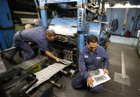 Printer Jose Lomeli (R) checks the first copies of the inaugural Los Angeles Register newspaper as it comes off the presses in Santa Ana, California April 16, 2014. REUTERS/Lucy Nicholson